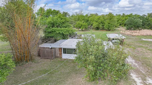 a aerial view of a house with a yard and trees