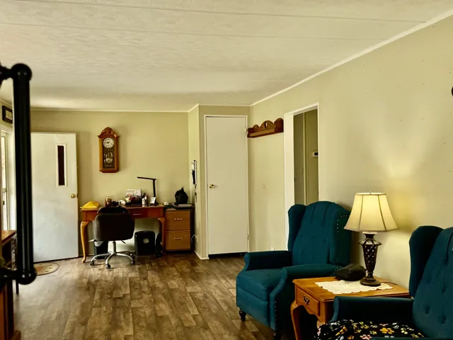 a kitchen with stainless steel appliances granite countertop a stove a sink a refrigerator a dining table and chairs with wooden floor