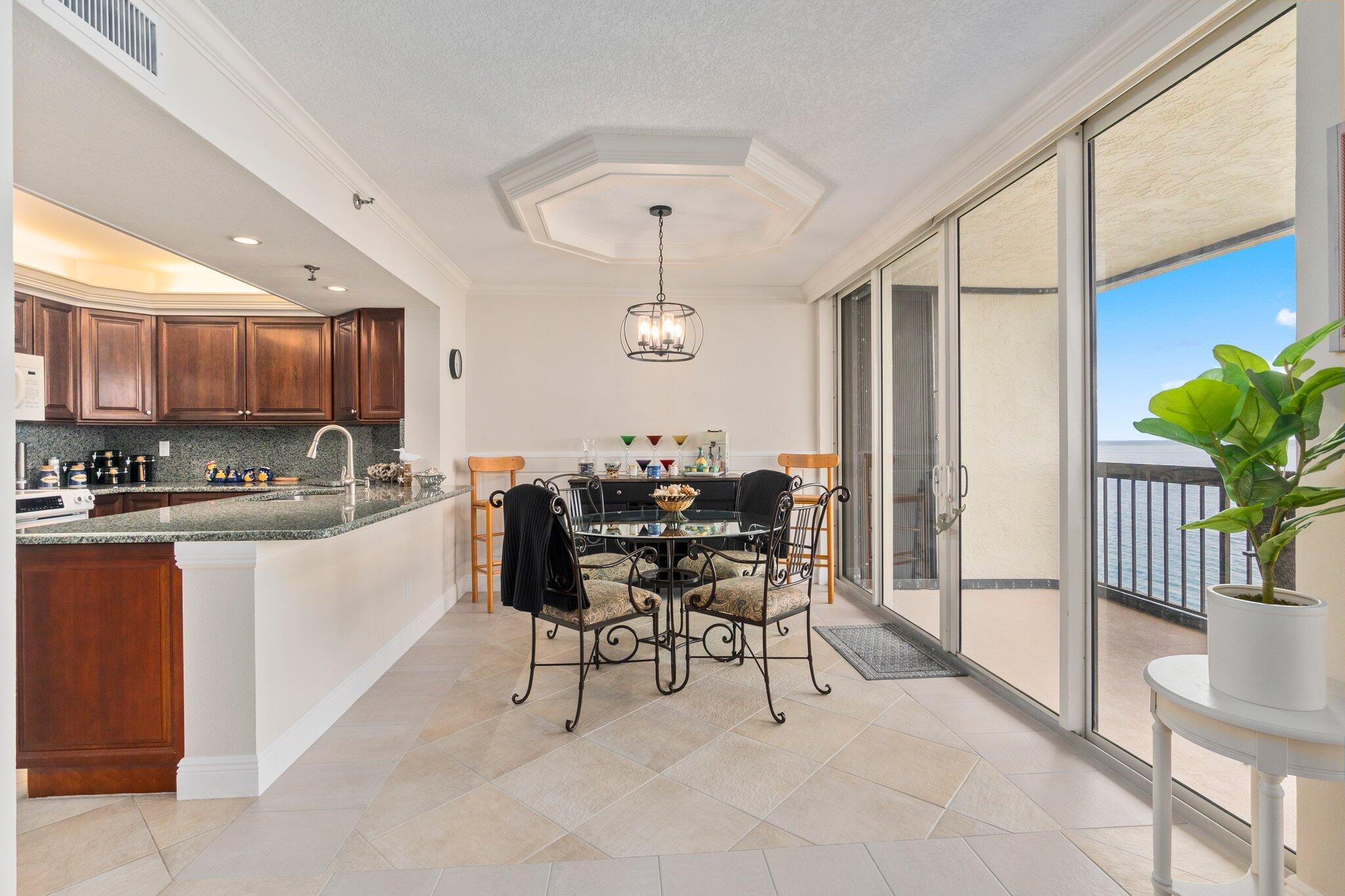 3100 North Hwy A1A, Unit PHA4 Fort Pierce, FL 34949 - Photo 14 of 54 a kitchen with stainless steel appliances granite countertop table chairs and a refrigerator