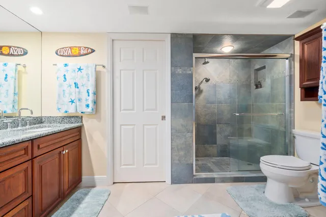 a en suite bathroom with a granite countertop double vanity sink and mirror