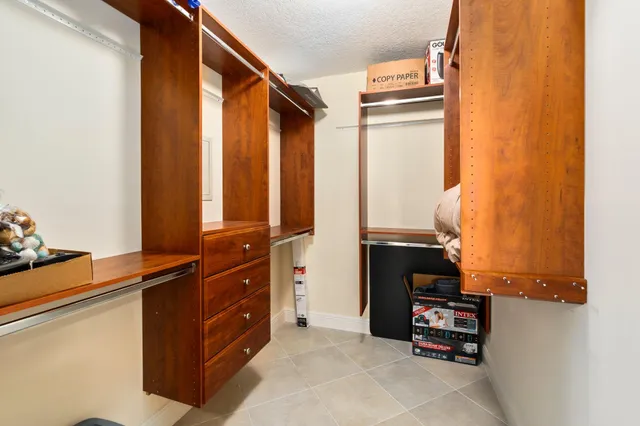 a bedroom with a bed and a flat tv screen on dresser