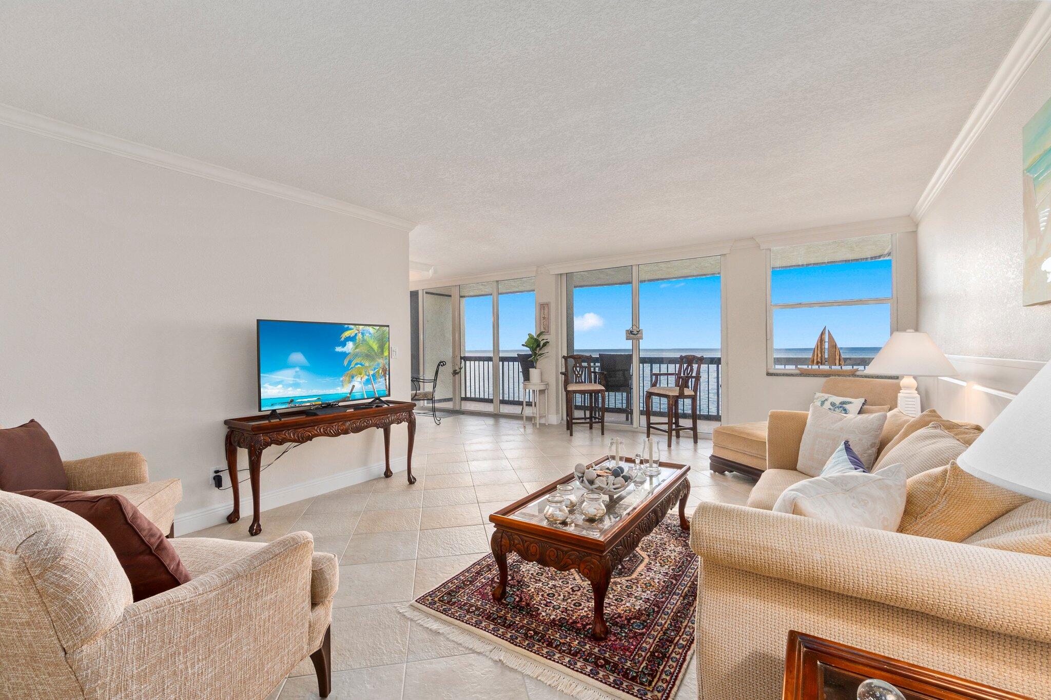3100 North Hwy A1A, Unit PHA4 Fort Pierce, FL 34949 - Photo 10 of 54 a living room with furniture a rug and a flat screen tv