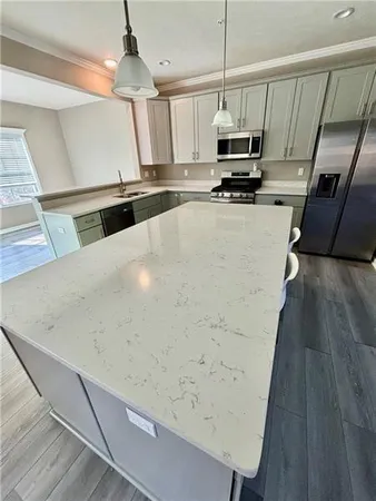 a kitchen with granite countertop a refrigerator a stove a microwave oven a sink and dishwasher with wooden floor