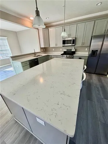 a kitchen with granite countertop a refrigerator a stove a microwave oven a sink and dishwasher with wooden floor