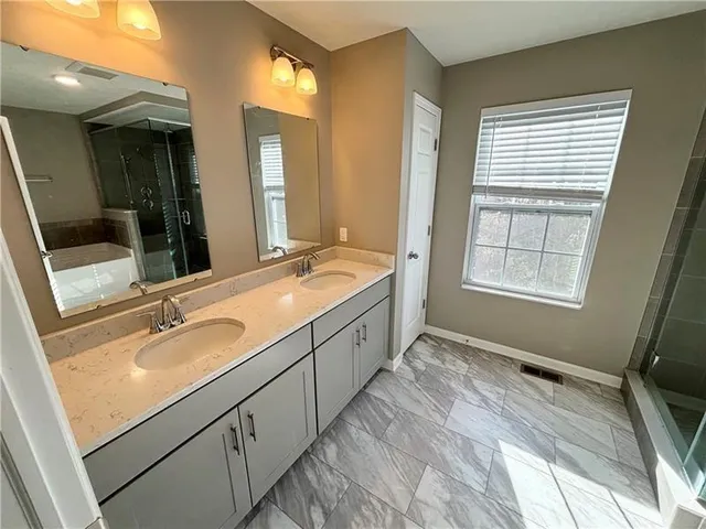 a spacious bathroom with a sink double vanity and a mirror