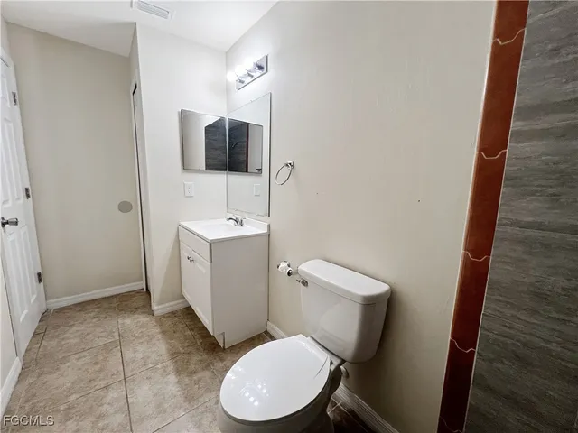 a white toilet sitting next to a bathroom sink