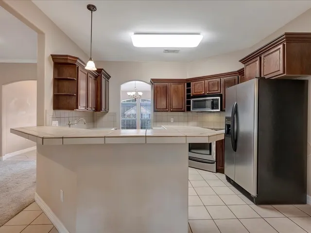 a kitchen with stainless steel appliances a refrigerator and microwave