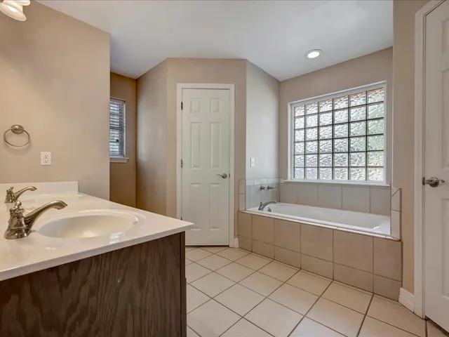 a spacious bathroom with a bathtub sink and mirror
