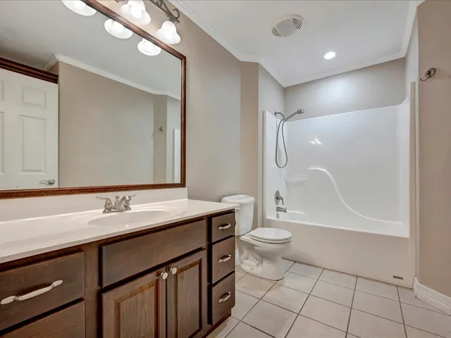 a bathroom with a granite countertop sink a toilet a mirror and shower