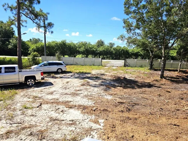 a view of swimming pool with lawn chairs and wooden fence