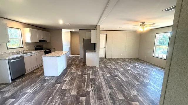 a view of a kitchen with wooden floor and electronic appliances