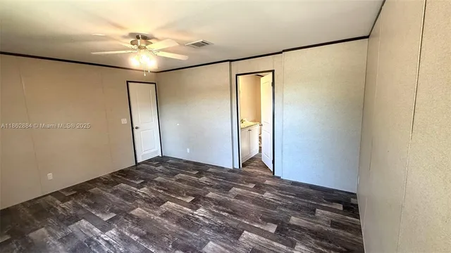 a view of a livingroom with a chandelier fan and a bathroom