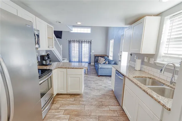 a kitchen with granite countertop a stove and a sink