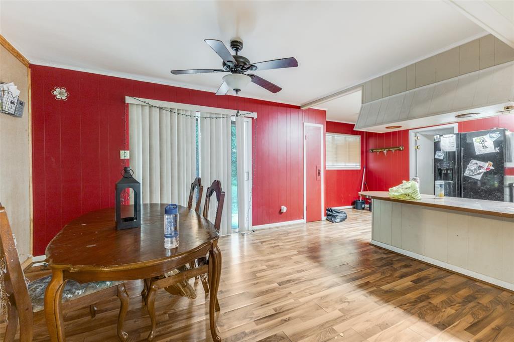 425 Lybrand Street Wills Point, TX 75169 - Photo 5 of 12 Dining area featuring light wood finished floors, ornamental molding, a ceiling fan, and wooden walls