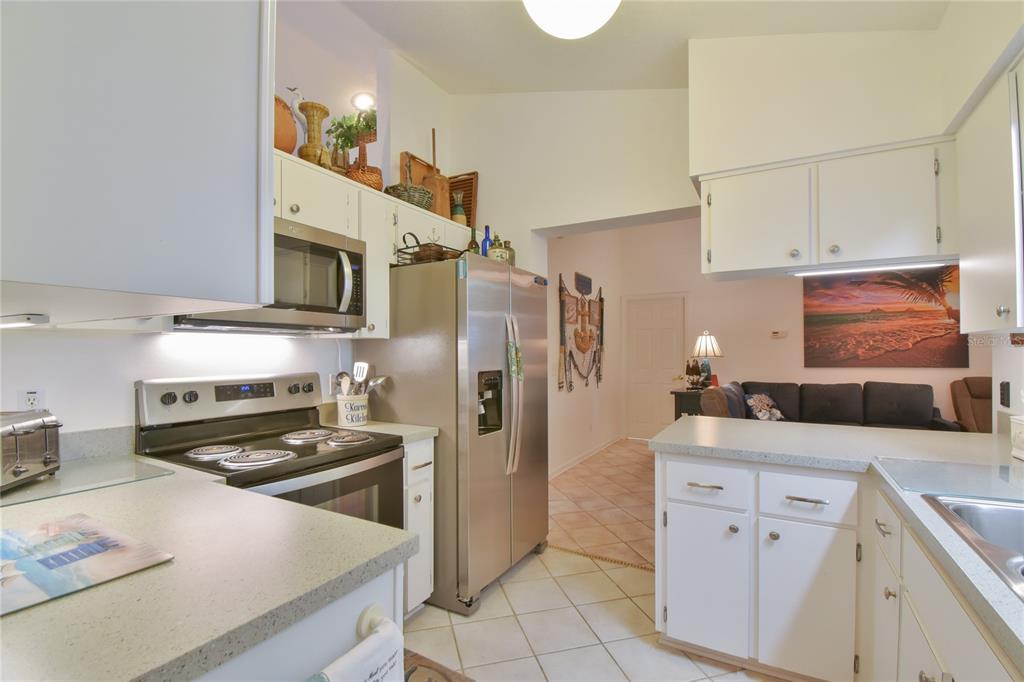 5366 Northwest 21st Loop Ocala, FL 34482 - Photo 7 of 36 a kitchen with white cabinets and stainless steel appliances