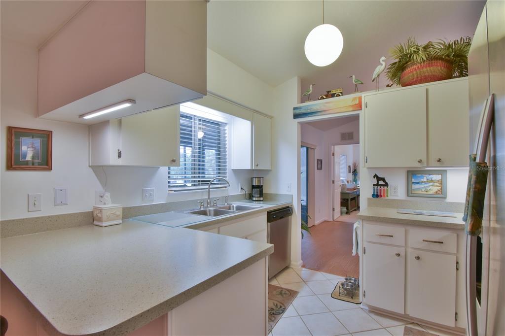 5366 Northwest 21st Loop Ocala, FL 34482 - Photo 8 of 36 a kitchen with a sink dishwasher stove and white cabinets next to a window