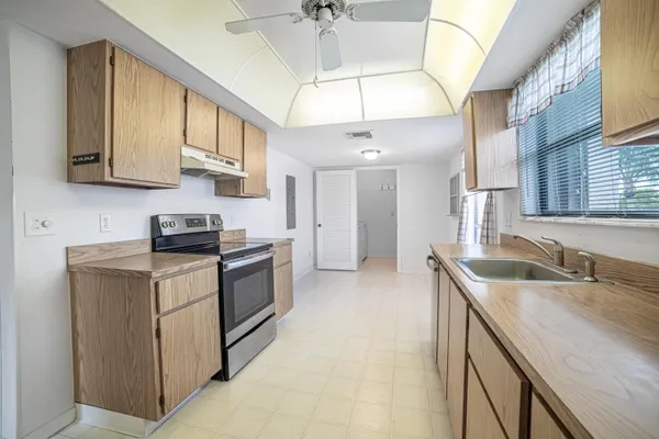 a kitchen with stainless steel appliances granite countertop a sink a stove and a refrigerator