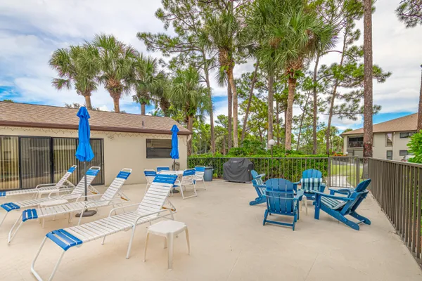a view of a house with pool and chairs