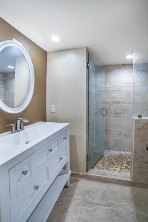 a bathroom with a double vanity sink mirror and shower