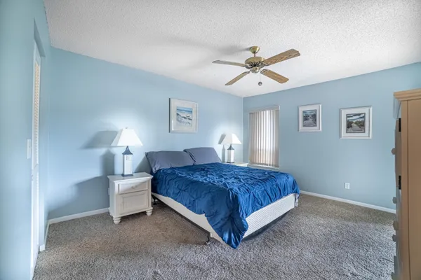 a spacious bedroom with a bed and a chandelier