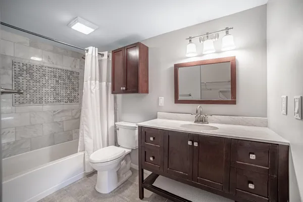 a bathroom with a toilet sink double vanity and mirror