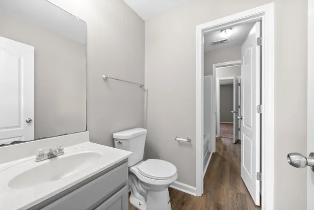 a bathroom with a toilet sink and mirror