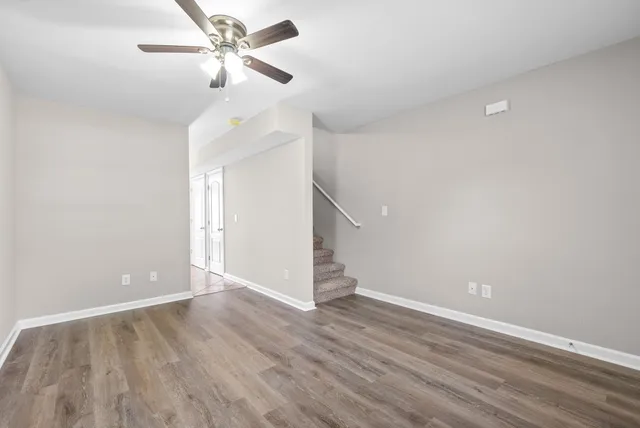 a view of a room with wooden floor and a ceiling fan