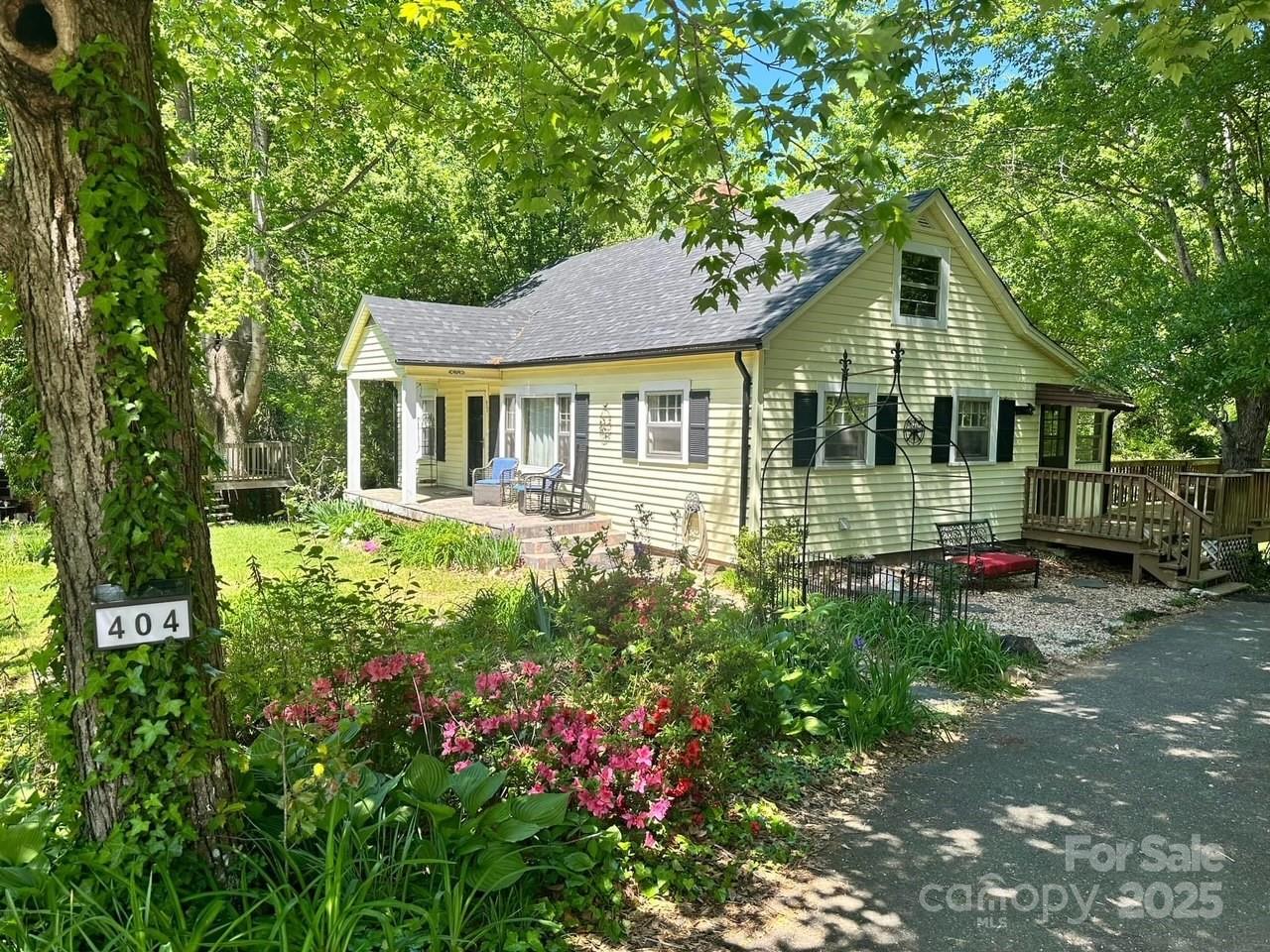 a front view of a house with a garden and trees