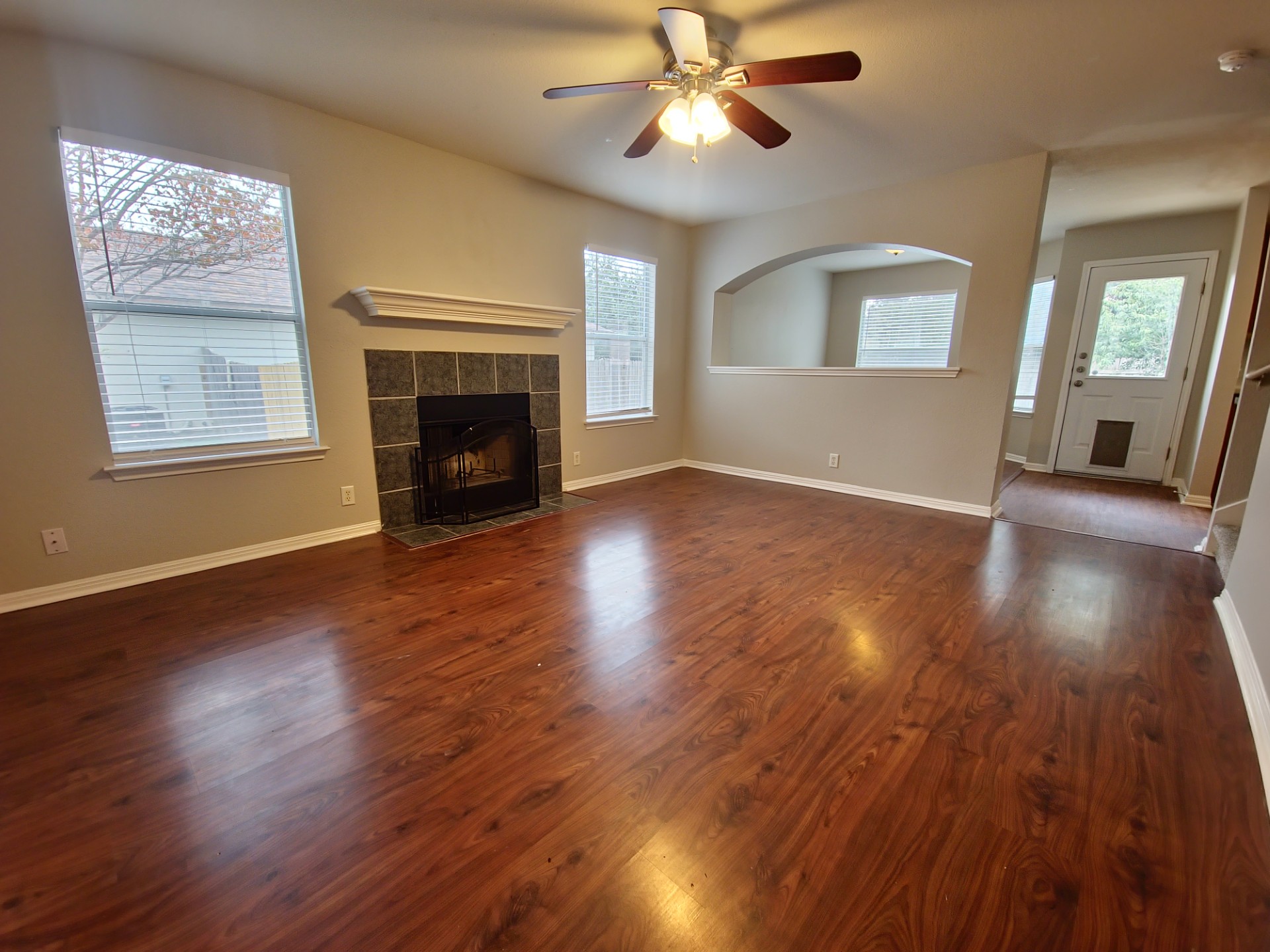 107 Orange Tree Lane Georgetown, TX 78626 - Photo 2 of 16 A welcoming living area features rich hardwood style flooring and a cozy fireplace, perfect for gatherings.