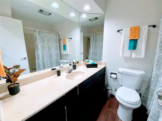 a bathroom with a sink a toilet and shower