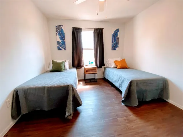 a bedroom with two beds and a large window