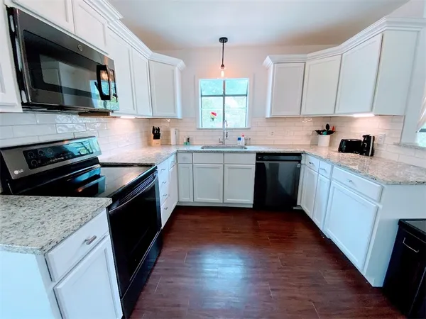 a kitchen with a sink stove and microwave