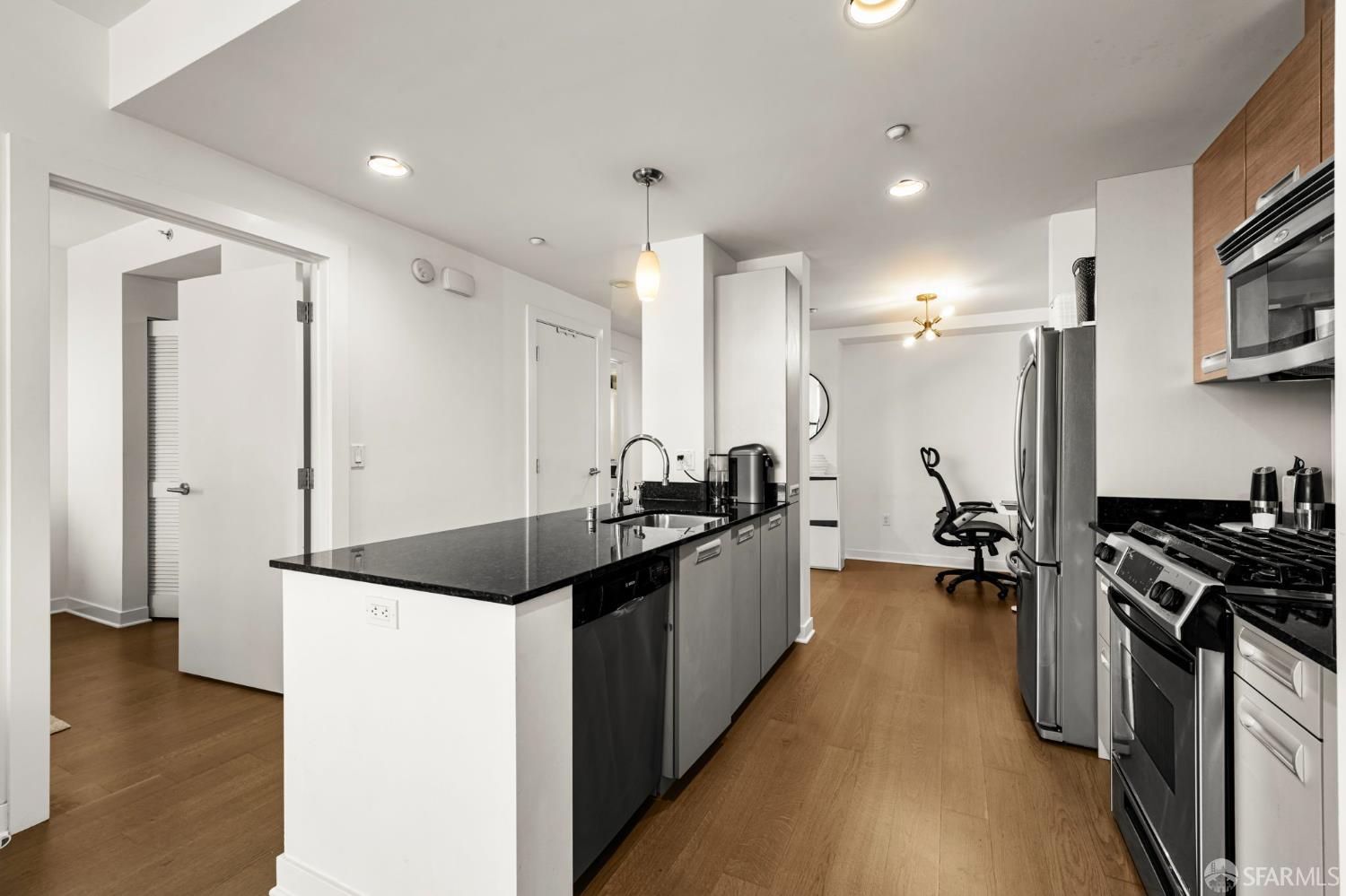 300 Berry Street, Unit 721 San Francisco, CA 94158 - Photo 12 of 27 a kitchen with granite countertop a sink a counter top space stainless steel appliances and cabinets