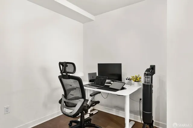 a view of a workspace with furniture and wooden floor