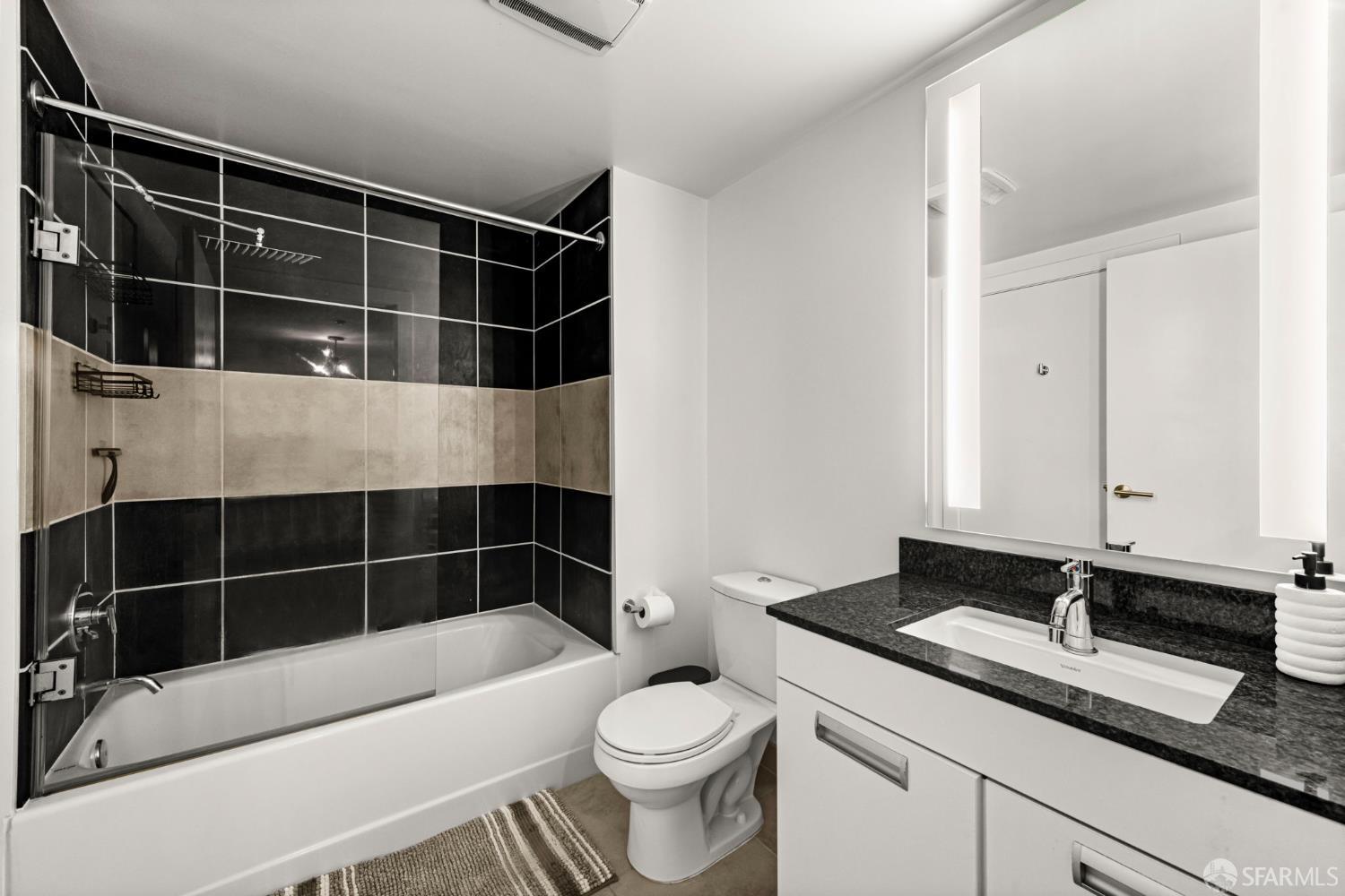 300 Berry Street, Unit 721 San Francisco, CA 94158 - Photo 19 of 27 a bathroom with a sink a toilet a mirror and shower