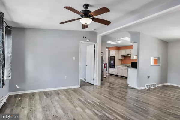 an empty room with wooden floor and a ceiling fan