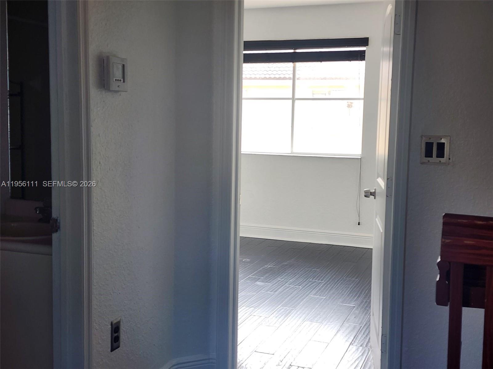 6970 Northwest 177th Street, Unit M103 Hialeah, FL 33015 - Photo 30 of 38 a view of an empty room with a window