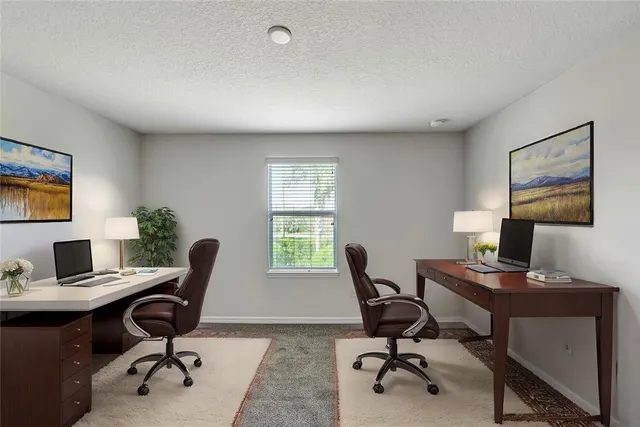 a view of a workspace with furniture and a window