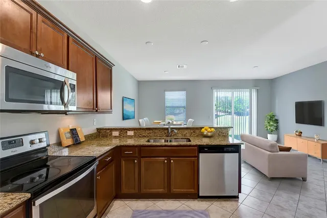 a kitchen with stainless steel appliances granite countertop a sink and a stove
