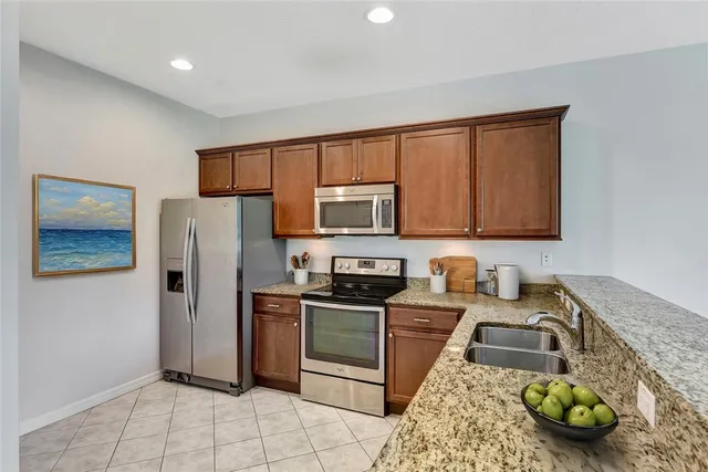 a kitchen with stainless steel appliances granite countertop a refrigerator sink and stove