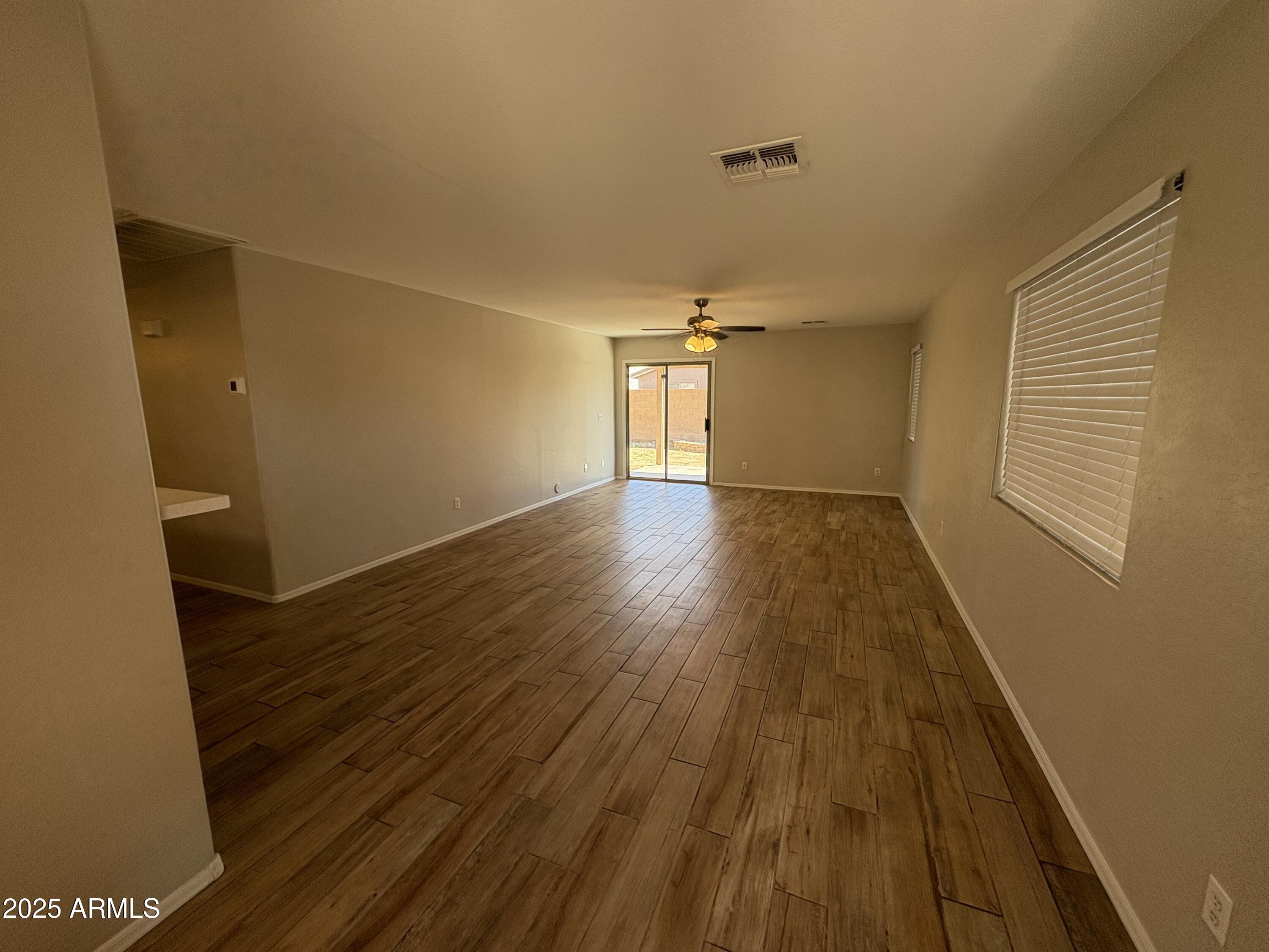 3323 South 80th Avenue Phoenix, AZ 85043 - Photo 2 of 7 an empty room with wooden floor and windows