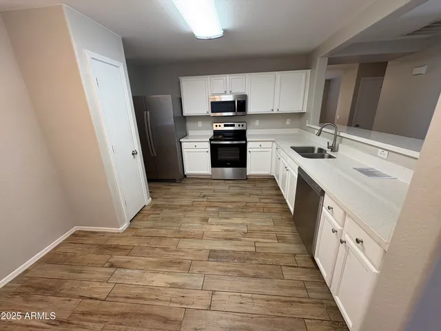 a large kitchen with a stove top oven sink and cabinets