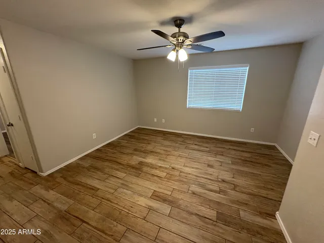 a view of a room with wooden floor and chandelier fan