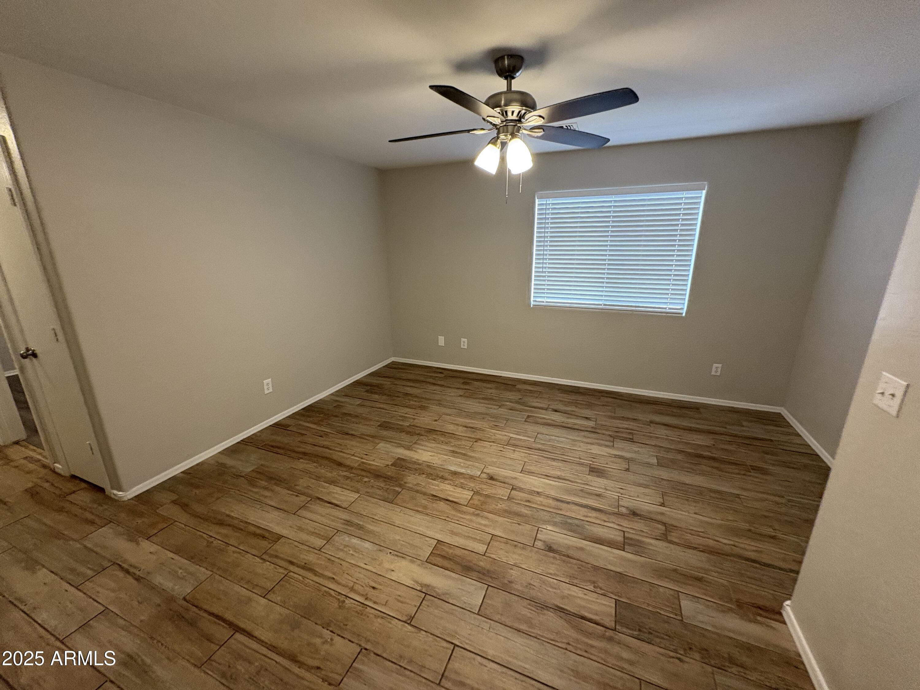 3323 South 80th Avenue Phoenix, AZ 85043 - Photo 4 of 7 a view of a room with wooden floor and chandelier fan