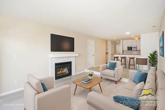 a living room with furniture a fireplace and a flat screen tv