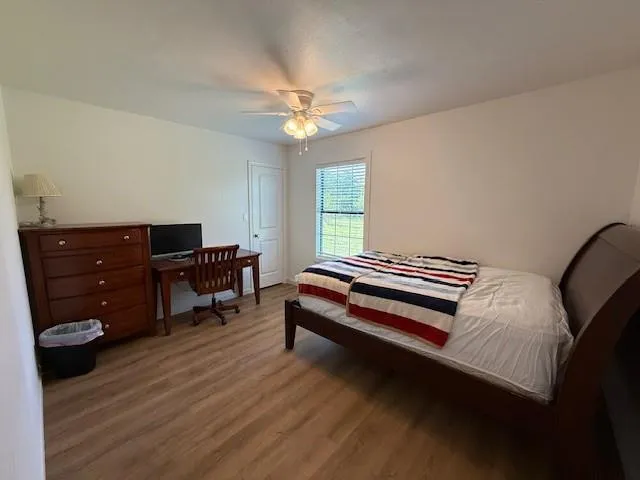 a bedroom with a bed and wooden floor