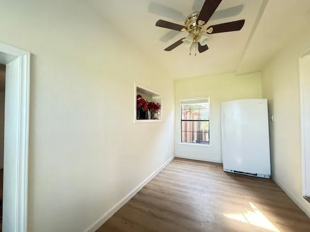 an empty room with windows and fan