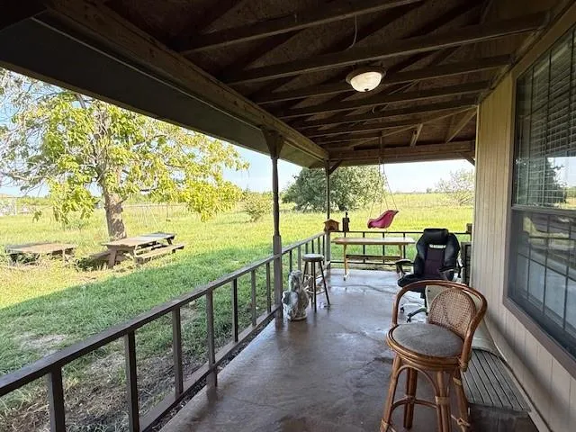 a view of a chairs and table in patio with a yard