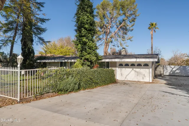 a view of a house with a yard and potted plants