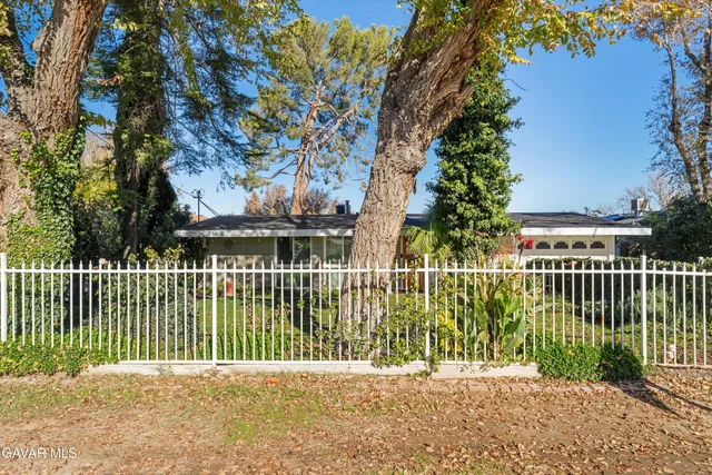 a street view with a fence and trees